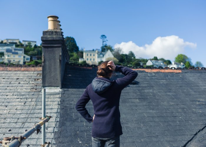 Rhode Island roof repair - woman surveying roof damage